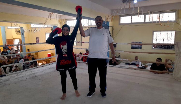 إحدى بطلات بطولة القناة للكيك بوكسينج مع أحد الحكام